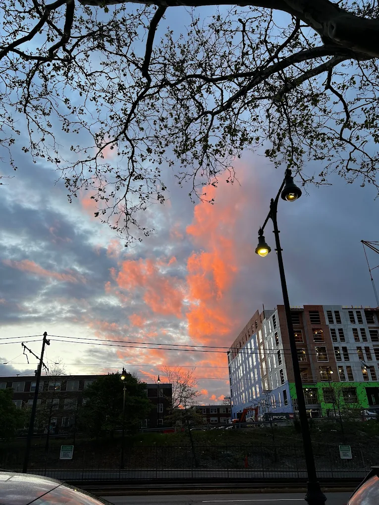 Sunset with orange clouds over city street