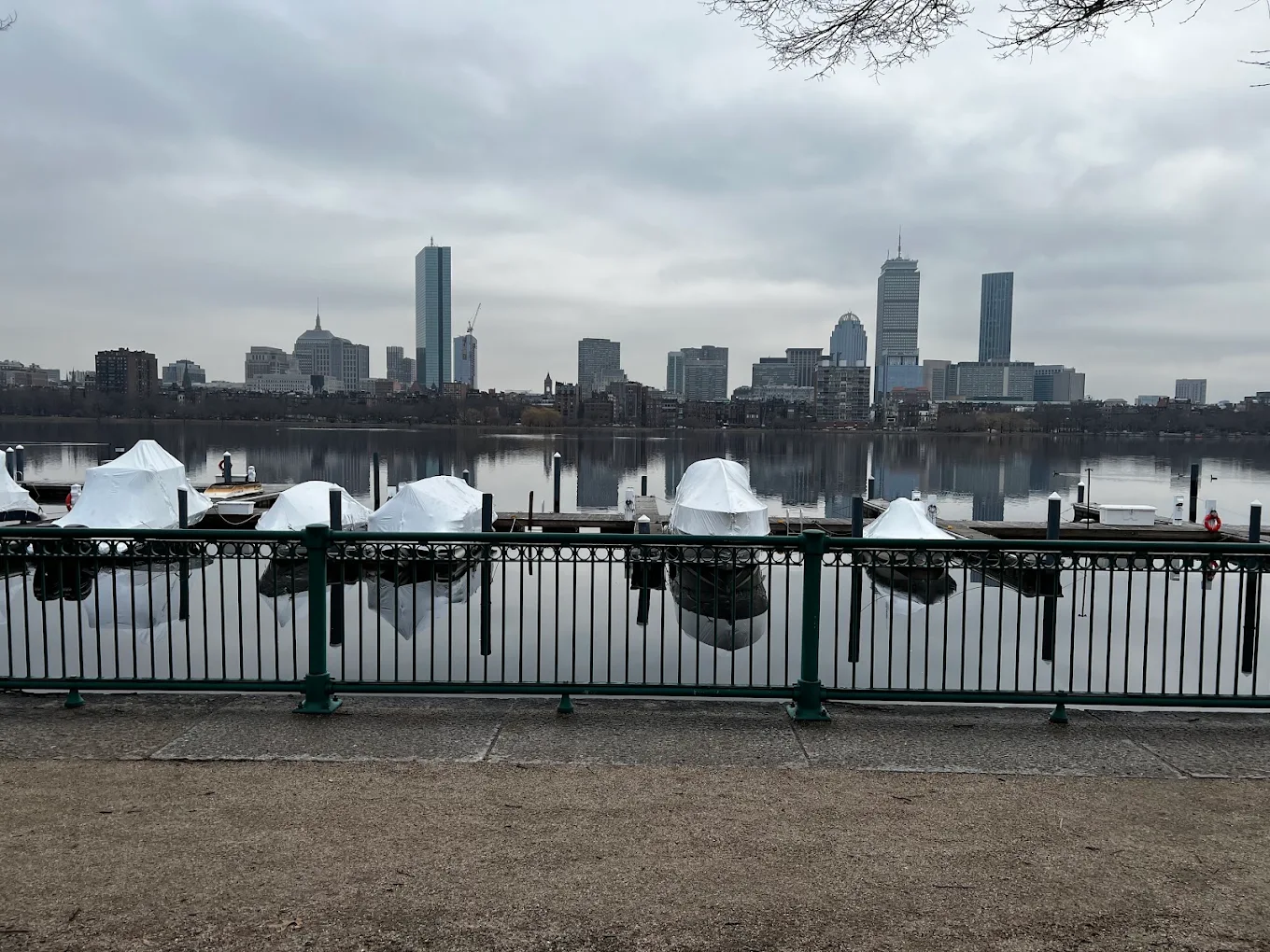 Boston skyline across river with covered boats